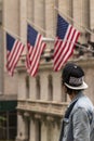 Man looking at USA American flags at Wall Street, New York, United States of America, North America