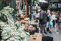 Man looking at the vegetables on a market stall in Borough Market, London, UK