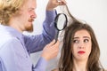 Man looking at woman hair through magnifer Royalty Free Stock Photo