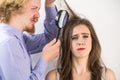 Man looking at woman hair through magnifer Royalty Free Stock Photo