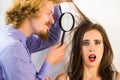 Man looking at woman hair using magnifer Royalty Free Stock Photo