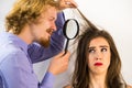 Man looking at woman hair using magnifer Royalty Free Stock Photo