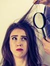 Man looking at woman hair using magnifer Royalty Free Stock Photo