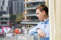 A man looks from the balcony at the city, Royalty Free Stock Photo