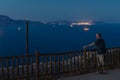 A man stands at the railing at night and looks at the bay lights with ships. Royalty Free Stock Photo