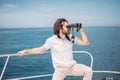 Man looks through binoculars from the boat