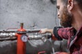 The man looks at the faucet, pipes, valve, pressure meter Royalty Free Stock Photo