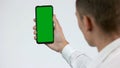 Man looks at green smartphone screen. Royalty Free Stock Photo