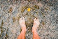 Man looks at his feet submerged in the water of a river on the pebbles