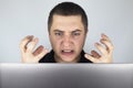 The man looks at the laptop, gets angry and annoyed about what he saw there. Expressing emotions and reacting to what you see on Royalty Free Stock Photo