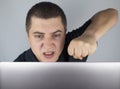 The man looks at the laptop, gets angry and annoyed about what he saw there. Expressing emotions and reacting to what you see on Royalty Free Stock Photo