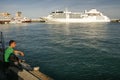 Man looks at large cruise ship in the port of Yalta, Crimea, Ukraine. June 2011 Royalty Free Stock Photo