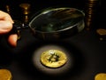 Man looks through magnifying glass on a Bitcoin btc coin. Assessment of crypto cost