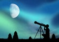 Man looks at the Northern Lights with the telescope