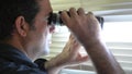 Man looks and searches with binoculars