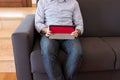 Man looks at the tablet sitting on the sofa