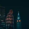 Man looks at a tower with red lights of Philadelphia City Hall at night Royalty Free Stock Photo