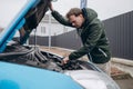 A man looks under the hood of a car. Royalty Free Stock Photo