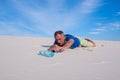 Man, lost in the desert reaches for the bottle of water