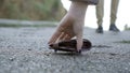 Man lost money purse on the street. Only his legs walking away in the picture, general focus on the wallet Royalty Free Stock Photo