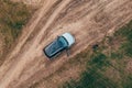 Man lost off-track on countryside road exiting out of the car and looking around, aerial shot from drone pov Royalty Free Stock Photo