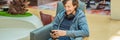 A man in the lounge area at the airport is waiting for his plane, uses a smartphone and headphones. Young smiling man Royalty Free Stock Photo