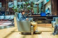 A man in the lounge area at the airport is waiting for his plane, uses a smartphone and headphones. Young smiling man Royalty Free Stock Photo