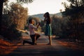 Man in love proposing a surprised, shocked woman to marry him at sunset. Proposal, engagement and wedding concept. Betrothal