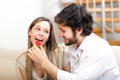 Man lovely feeding his girlfriend on the couch Royalty Free Stock Photo