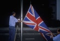 Man lowering British Union Jack flag in Hong Kong Royalty Free Stock Photo