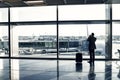 Man with luggage waiting hall of airport at window glass Royalty Free Stock Photo