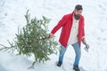 Man lumberman with Christmas tree in winter park. Happy winter time. Bearded Man cutting Christmas tree. Happy father