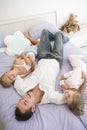 Man lying in bed with two young girls smiling Royalty Free Stock Photo