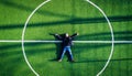 Man lying on the center of football field, top view Royalty Free Stock Photo