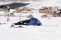 Man lying on cold snow after ski crash at Sierra Nevada resort in Spain with mountains