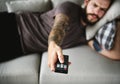 Man lying on a couch watching tv