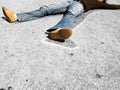 Man lying in dead man chalk outline on concrete