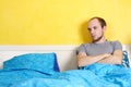 Man lying in double bed and looking on empty seat