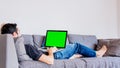 Man lying down on sofa with laptop computer Royalty Free Stock Photo