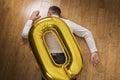 The man lying on the floor was crushed by a toy inflatable zero. Zeroing concept Royalty Free Stock Photo