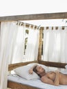 Man Lying In Four Poster Bed Royalty Free Stock Photo