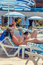 A man is lying on a lounger and reading a book. People on vacation on a summer day by the outdoor pool. Tourists in a multi- Royalty Free Stock Photo