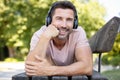 man lying on park bench with headphones Royalty Free Stock Photo