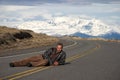 Man lying on the road with the mountain behind