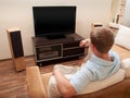 Man lying on sofa watching TV Royalty Free Stock Photo