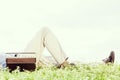 Low section of man lying by vintage radio on grass against clear sky