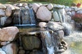 A man made double waterfall constructed from boulders and rocks falling into a pond at Sinnissippi Gardens