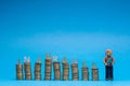 Man made from plasticine holding a house model to the right of a bunch of columns made from coins, with the word insurance placed Royalty Free Stock Photo