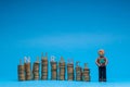 Man made from plasticine holding a house model to the right of a bunch of columns made from golden coins, with the word insurance Royalty Free Stock Photo
