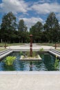 A man made pond with water plants and a sculpture at Boerner Botanical Gardens